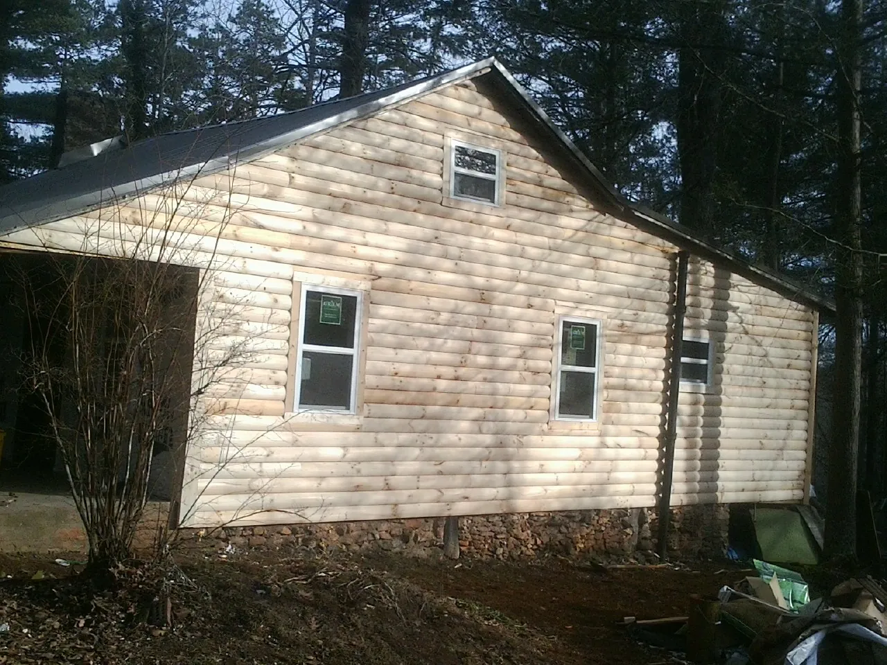 New log siding and dark metal roofing on a gable end in Raeford