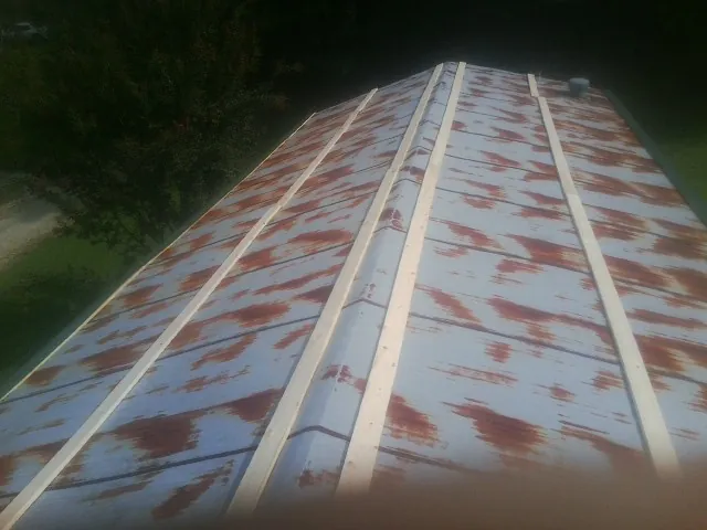 Rusted metal roof panels with new wood purlins before replacement — Storm Damage Roof Repair in Raeford by Roofing Brothers