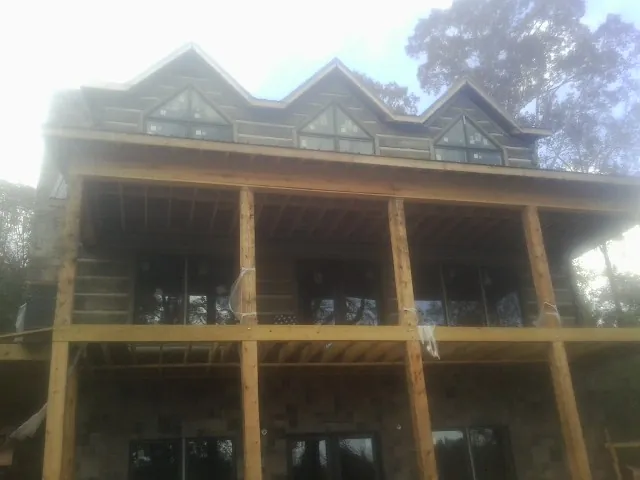 Dormers and porch framing on a large log home under construction — Roof Coating work by our crew in Raeford