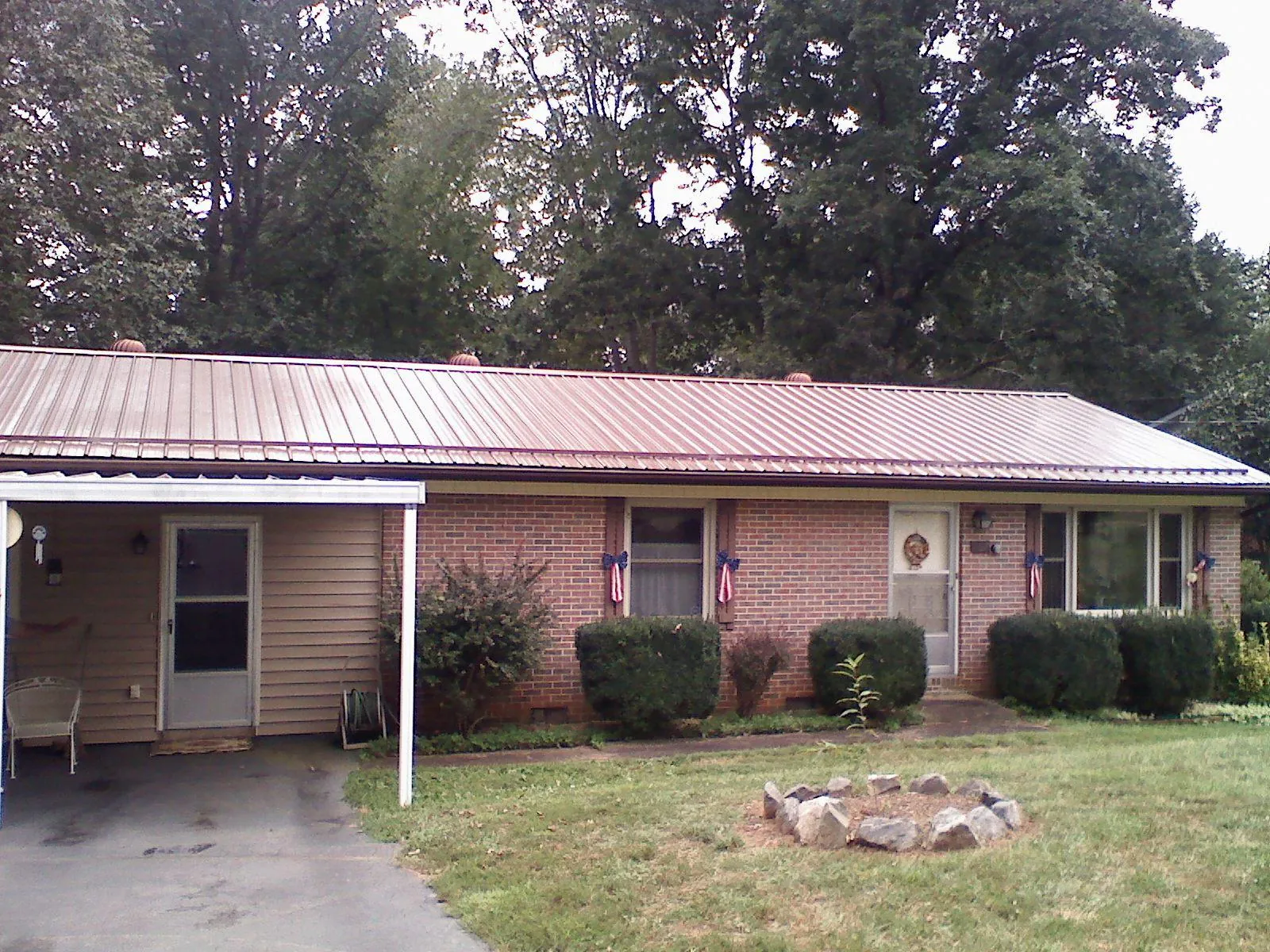 Bronze metal roof and carport on a brick ranch home — Roof Repair work by our crew in Raeford