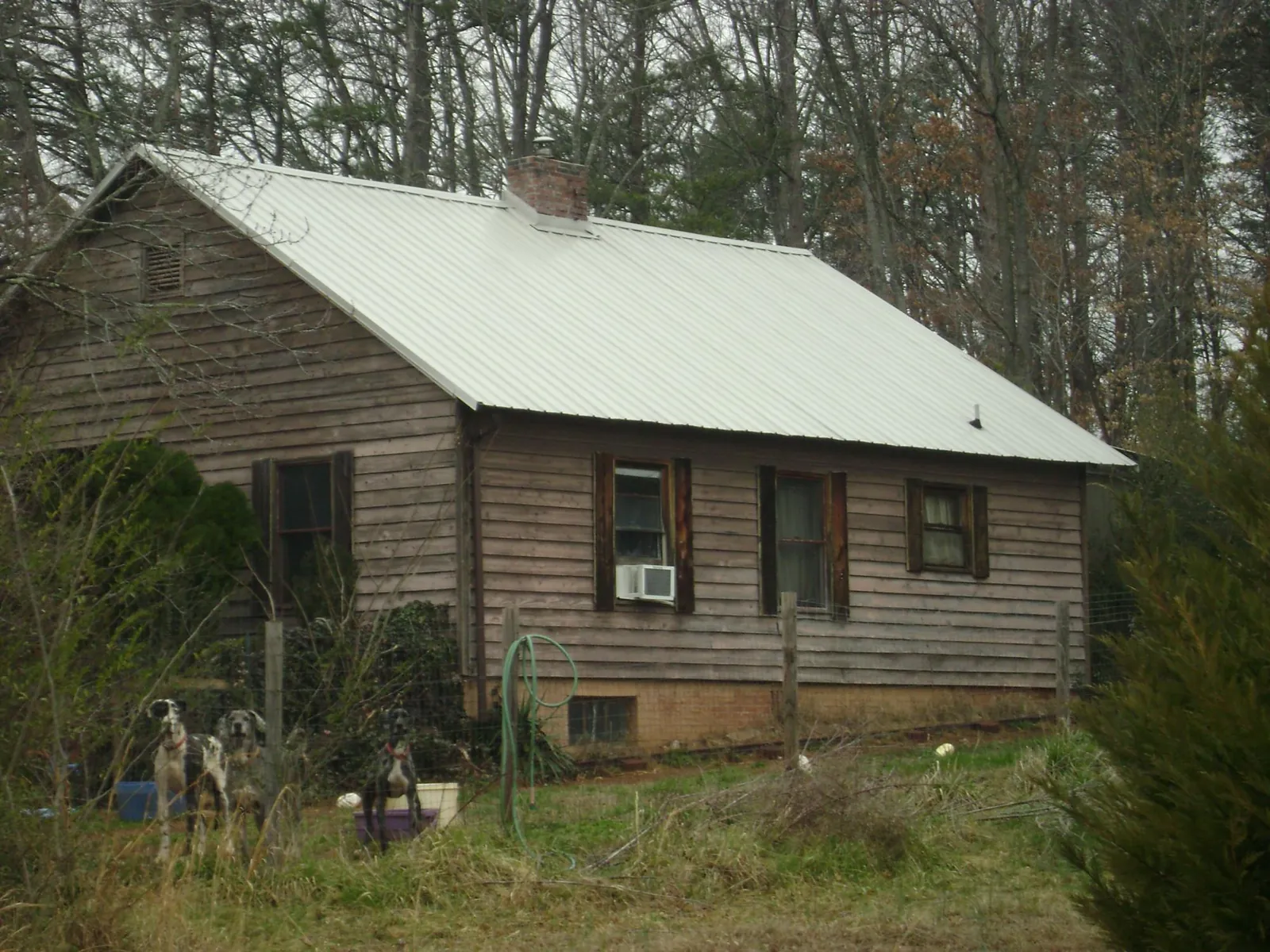 White metal roof on an old wood sided farmhouse, from a Asphalt Shingle Roof Repair job in Raeford